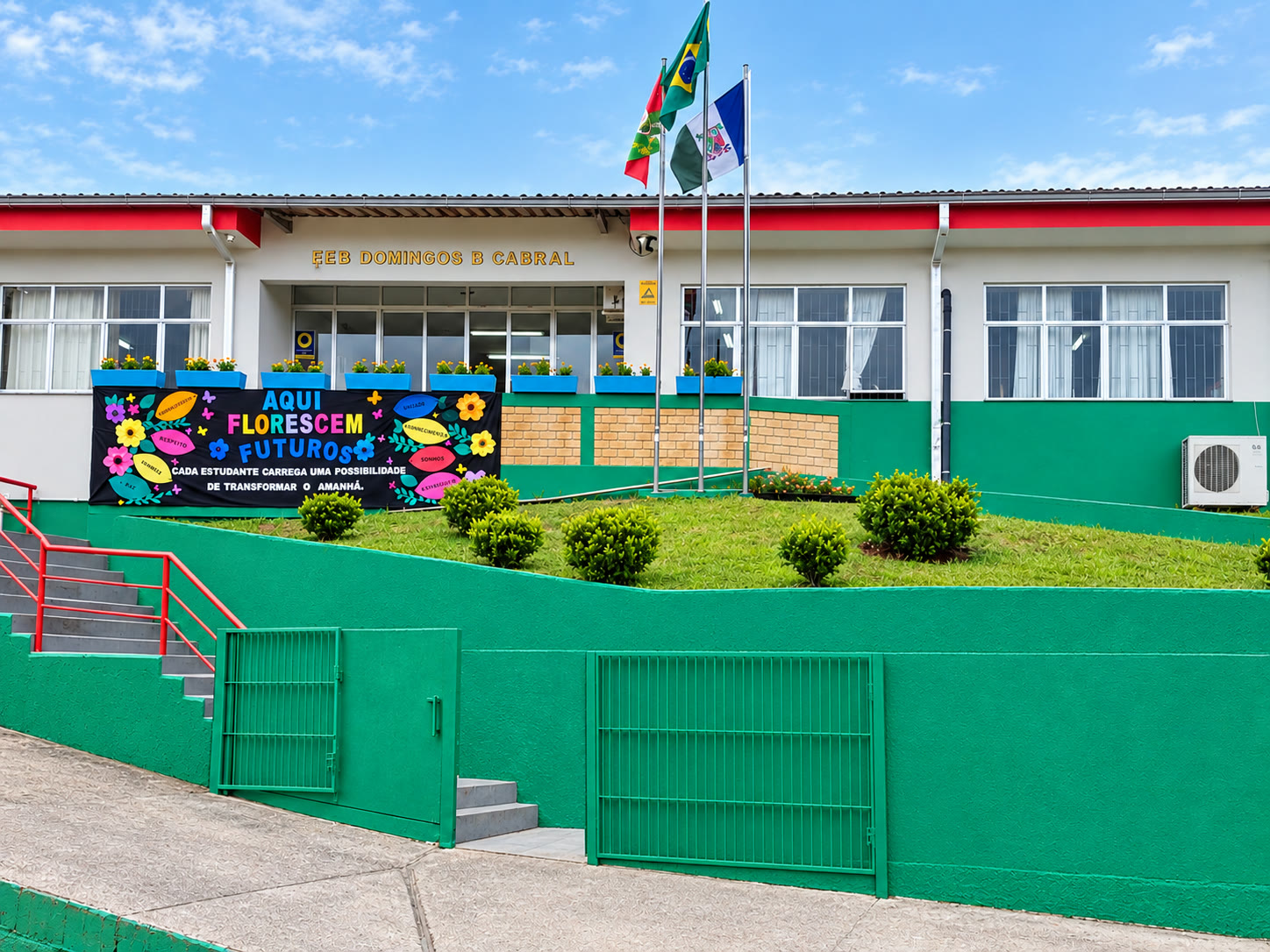 Fachada da EEB Domingos Barbosa Cabral com a faixa 'Aqui florescem futuros'
